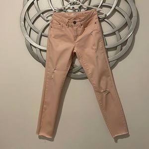 Peachy pink distressed skinny jeans.